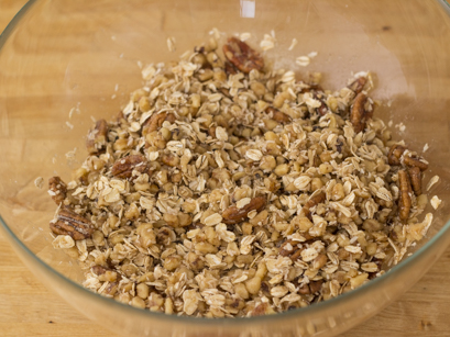 Des noix de grenoble et pacanes mélangés avec de l'avoine et noix de coco dans un bol en verre