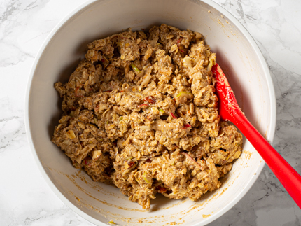 Ingrédients liquides et secs mélangés dans une casserole avec une cuillère à remuer