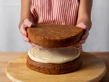 La moitié supérieure d’un gâteau rond étagé qui se fait déposer sur la moitié inférieure