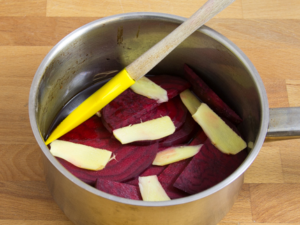 Casserole avec les tranches de betterave et le gingembre, et une spatule