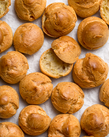 Des petits choux, dont un tranché, sur du papier parchemin