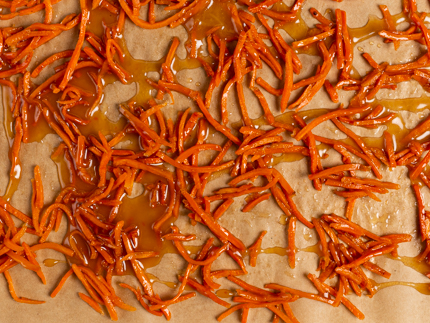 Carottes râpées enrobées de sirop sucré sur du papier parchemin