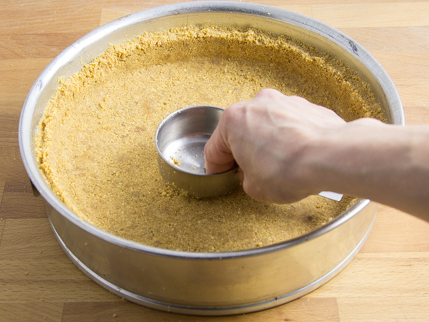 Mélange à croûte se faisant compresser dans un moule à charnière à l’aide d’une tasse à mesurer