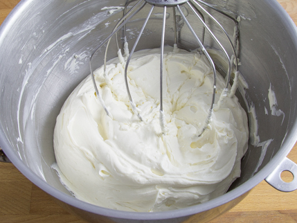  Garniture au fromage à la crème dans le bol d’un batteur sur socle muni du fouet