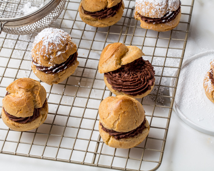 Choux farcis de ganache au chocolat refroidissant sur une grille