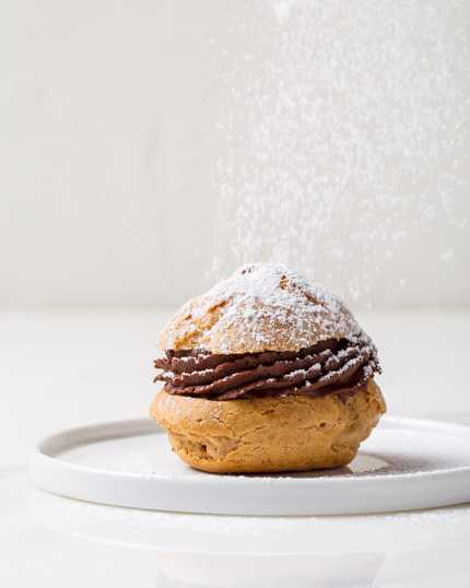 Choux farcis de ganache au chocolat, saupoudrés de sucre à glacer