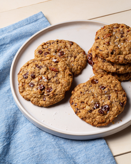 Biscuits cowboy avec pépites de chocolat, pépites de caramel et pacanes sur une assiette avec une serviette bleue 