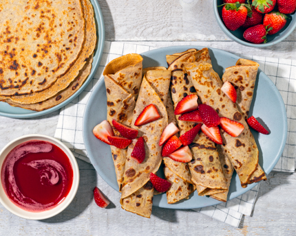 Une assiette de pannenkoeken, ou crêpes hollandaises, avec fraises et sirop fraise-hibiscus