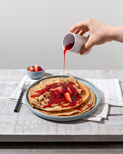 Une assiette de pannenkoeken, ou crêpes hollandaises, avec fraises et sirop fraise-hibiscus