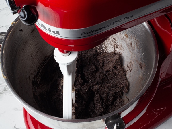 Mélange de pâte à biscuits au chocolat noir dans le bol d’un batteur sur socle