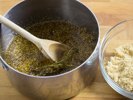 Casserole remplie de thym, d’eau et de fleurs de sureau, avec une cuillère de bois>