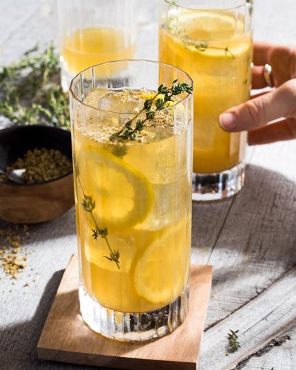 Deux verres de limonade sur glace garnis de quartiers de citron et de thym