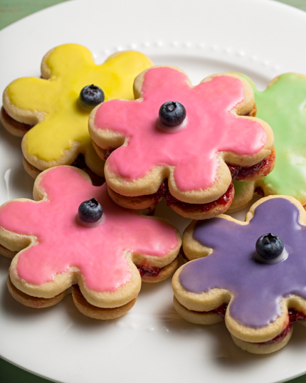 Pile de biscuits sandwichs glacés en forme de fleurs dans une assiette