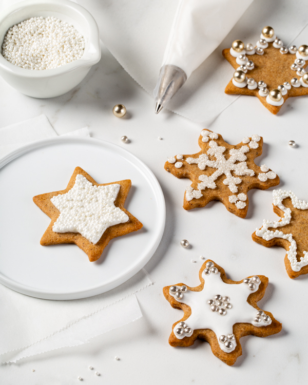 Biscuits au mélange à pain d’épices décorés de glaçage royal, une poche à douille et un sac de confettis comestibles