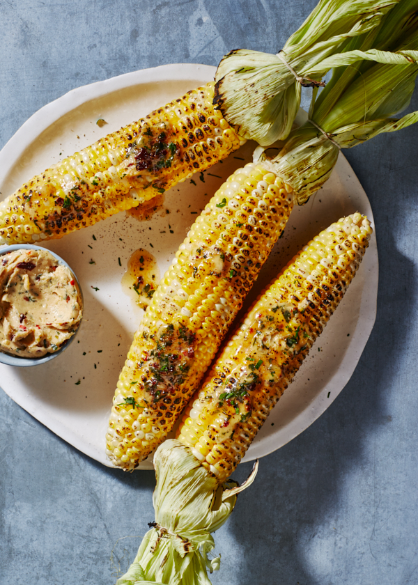 Épis de maïs grillés sur un plateau avec un bol de beurre au chipotle-lime.