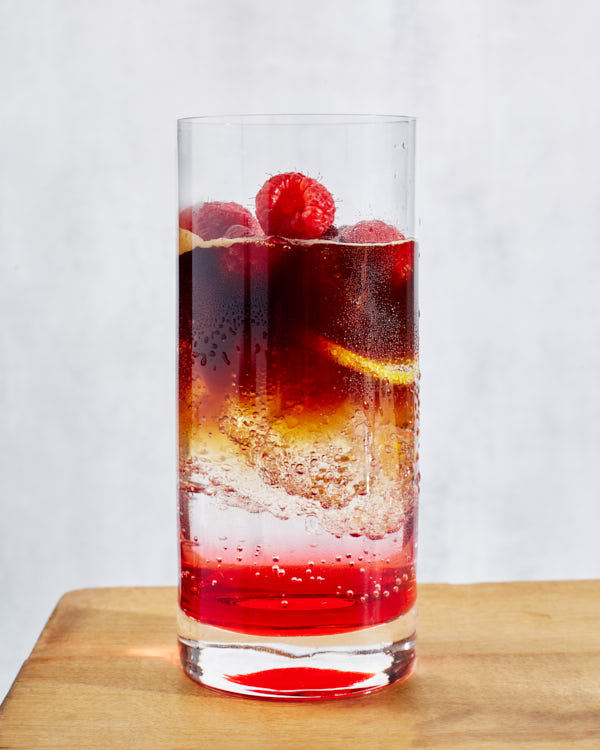 Un verre de tonic espresso glacé à la framboise sur une table en bois