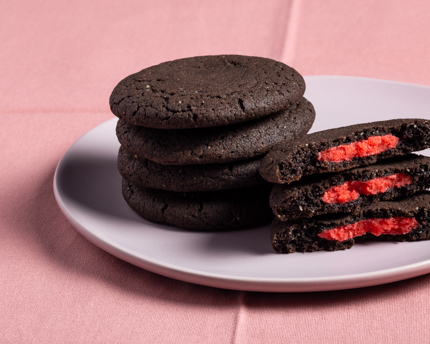 Piles de biscuits au chocolat noir farcis de pâte d’amande rouge