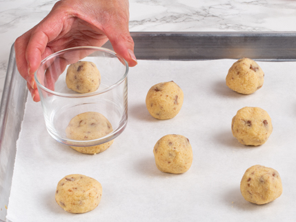 Aplatir la pâte à l’aide d’un verre à fond plat, sur une plaque à pâtisserie