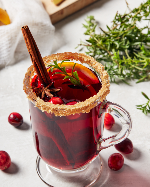 Une tasse de vin chaud garnie d’un givrage de cassonade, d’un bâton de cannelle, d’anis étoilé et de romarin