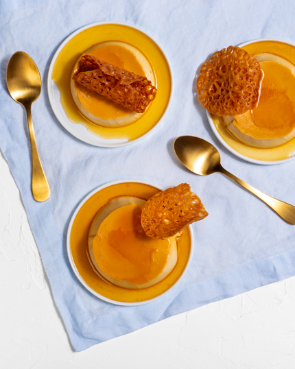 Trois crème caramel avec tuiles sur assiettes avec cuillère