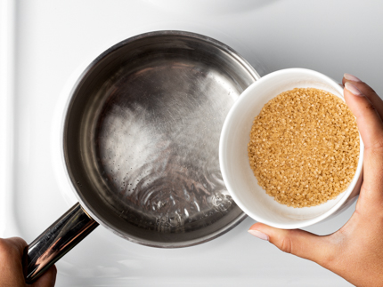 Sucre Turbinado Simplement Brut™ Redpath versé d’un bol à une casserole d’eau