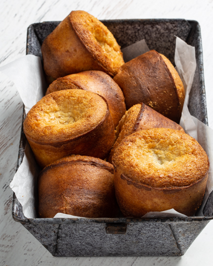 Sept popovers d’épeautre avec sirop de citron dans un plat de service avec une serviette