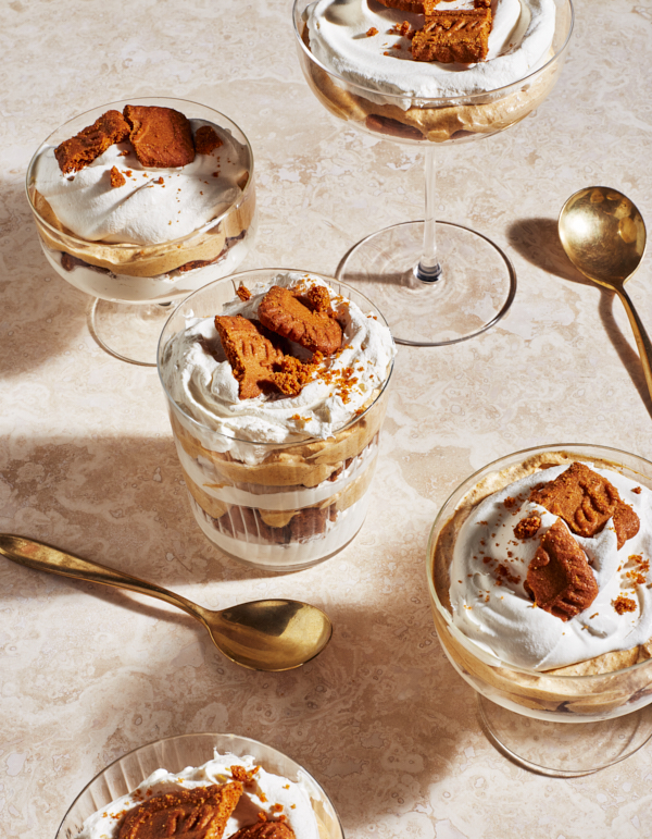 Des portions individuelles de gâteau au fromage et à la citrouille avec des biscuits croustillants servies avec des cuillères dorées.