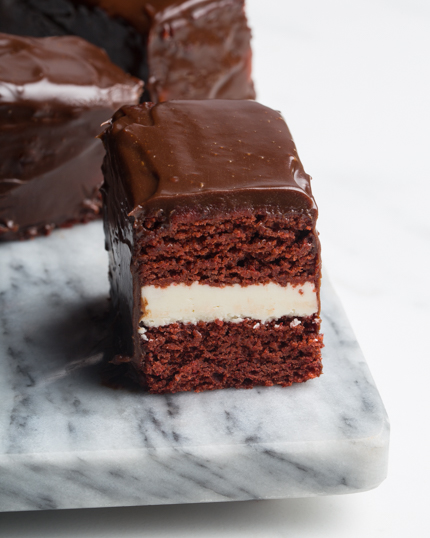 Gâteau red velvet trempé dans du chocolat sur une planche à découper