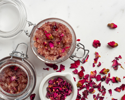 Pots d’exfoliant au sucre biologique et à l’eau de rose avec des pétales