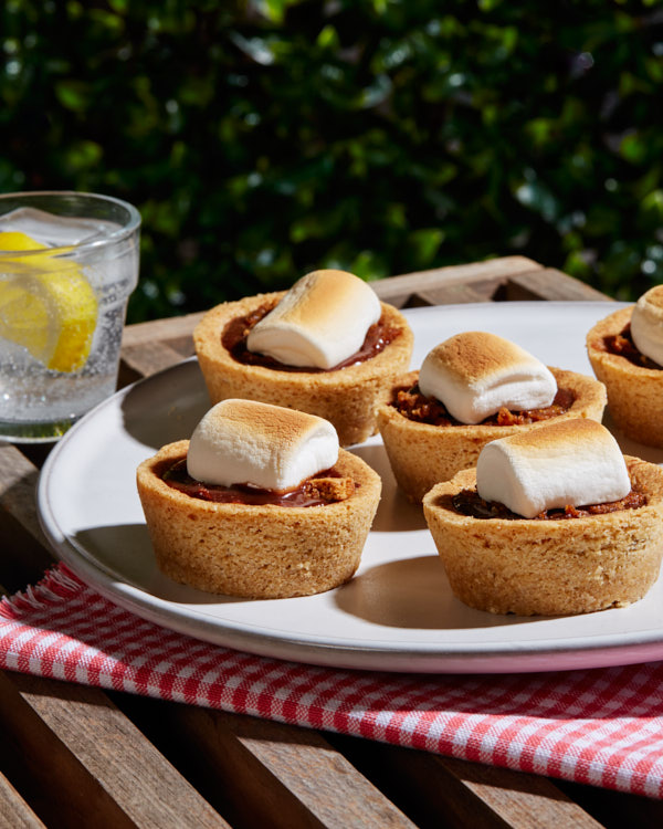 Coupes de biscuits S'mores sur un plateau en plein air avec une boisson pétillante