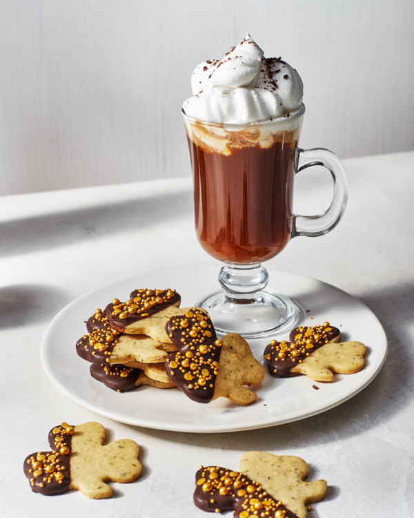 Des biscuits à la menthe en forme de trèfle trempés dans le chocolat et parés de paillettes dorées,