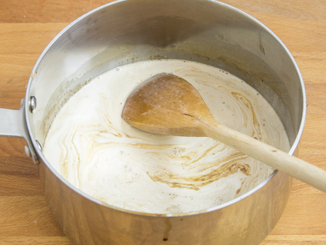 Petite casserole avec lait et sirop à la stout, et une cuillère de bois