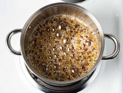  Le sucre en pleine ébullition dans une casserole sur une cuisinière