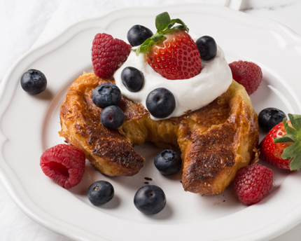 Un croissant cuit garni de crème fouettée et de petits fruits