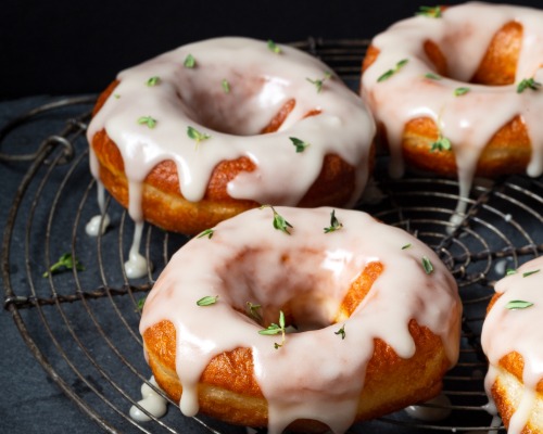 Cinq beignets à la levure sur une grille de refroidissement avec un glaçage au thym