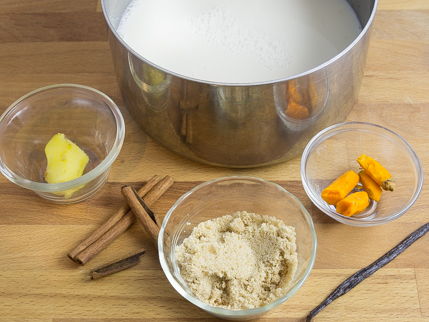 Une casserole de lait entourée de cannelle, vanille, gingembre, cassonade dorée et curcuma