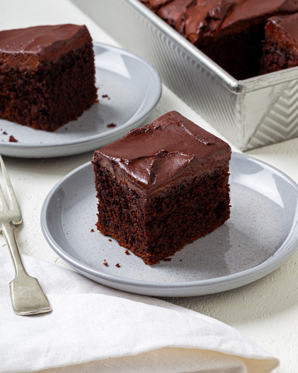 Carrés de gâteau végétalien au chocolat (en plaque) glacé sur des assiettes