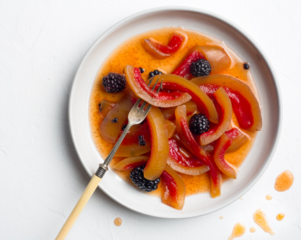 Une assiette de blanc de melon d’eau mariné et de mûres avec une fourchette