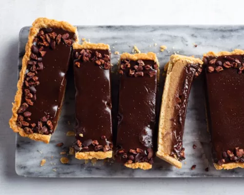 Pointes de tarte à la ganache et aux châtaignes sur une planche à découper en marbre