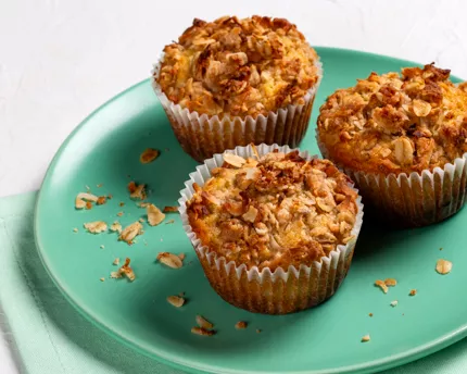 Trois muffins avec garniture streusel à la noix de coco sur une assiette verte