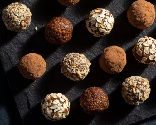 Un assortiment de boules aux figues enrobées de noix et de poudre de cacao