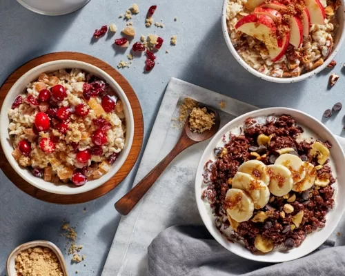 Trois bols de flocons d'avoine faits maison avec de la cassonade, des fruits et des baies.