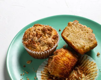 Deux muffins ananas et lime sur une assiette verte, l’un coupé en deux 