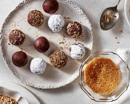 Boules de bourbon épicées sur un plateau, garnies de sucre glace, de noix concassées et de sucre turbinado