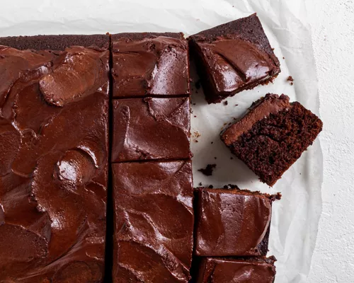 Gâteau végétalien au chocolat (en plaque) glacé de ganache au chocolat et coupé en carrés