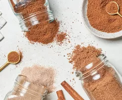 Trois bocaux de sucre à la cannelle renversés sur une table