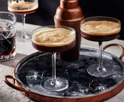 Deux verres de martini espresso sur un plateau avec un shaker à cocktail et un pichet en verre de martini