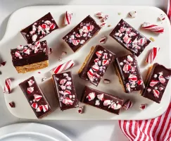 Barres de pâte à biscuits recouvertes d’une ganache au chocolat assortie de morceaux de bonbons à la menthe sur un plateau