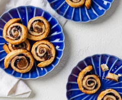 Trois assiettes bleues avec des pets-de-sœur aux bleuets sur une surface blanche