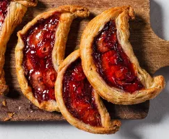 Quatre galettes aux fraises et aux dattes sur une planche à découper en bois